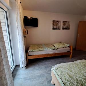 a bedroom with two beds and a tv on the wall at Fewo-Hengesbach in Much
