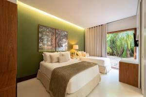 ein Hotelzimmer mit 2 Betten und einem Fenster in der Unterkunft Casa 3A Tivoli Ecoresidences in Praia do Forte
