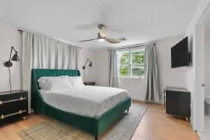 a bedroom with a green bed and a window at Little Creek Retreat - RIBryan Property in Middletown