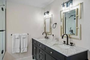 a bathroom with two sinks and two mirrors at Little Creek Retreat - RIBryan Property in Middletown +33 photos