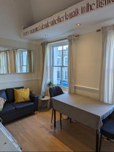 a living room with a table and a couch at 2 bed in the Heart of Stoke Newington in London