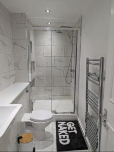 a white bathroom with a toilet and a shower at 2 bed in the Heart of Stoke Newington in London
