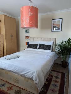 a bedroom with a large white bed with a red lamp at 2 bed in the Heart of Stoke Newington in London