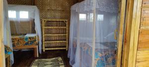 Fort Portal的住宿－Mwamba Kelele Lodge，一间卧室配有床和带窗帘的窗户