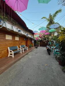 a building with benches and umbrellas in front of it at Posada Amaripucci in San Andrés