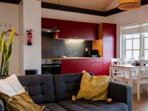 uma sala de estar com um sofá e uma cozinha em Cozy chalet with palet stove em De Veenhoop
