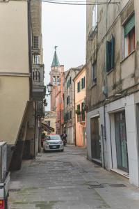 a car parked on a street with a clock tower at BATTISTI HOSPITALITY - motocicletta in Chioggia