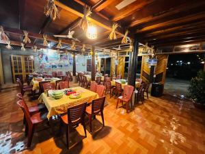 a restaurant with tables and chairs in a room at Homestay Yến Long in Hữu Lũng