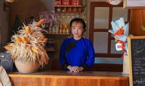 Homestay Yến Long في Hữu Lũng: بنت صغيرة تقف عند كونتر في مطعم