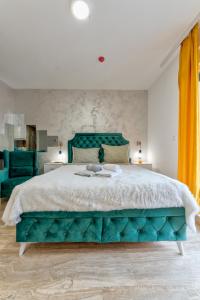 een slaapkamer met een groot bed met een groen hoofdeinde bij M&L Apartman Zlatibor in Zlatibor