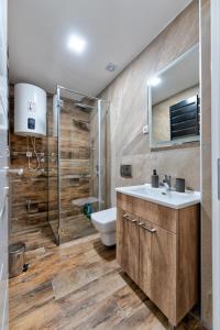 een badkamer met een toilet, een wastafel en een douche bij M&L Apartman Zlatibor in Zlatibor