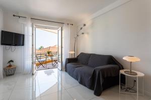 un salon avec un canapé et un balcon dans l'établissement Cap Ferrat View III AP4401 By Riviera Holiday Hom, à Saint-Jean-Cap-Ferrat
