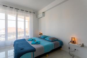 Un dormitorio con una cama con almohadas azules y una ventana en Cap Ferrat View III AP4401 By Riviera Holiday Hom, en Saint-Jean-Cap-Ferrat