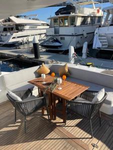 un tavolo e sedie in legno su un molo con barche di Yate Hotel STV a Barcellona