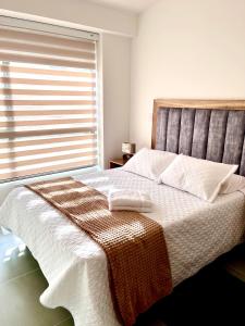 Un dormitorio con una cama grande con una manta. en Casa Turística en el Quindío, en La Tebaida