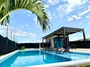 a swimming pool with chairs next to a building at Casa Turística en el Quindío in La Tebaida