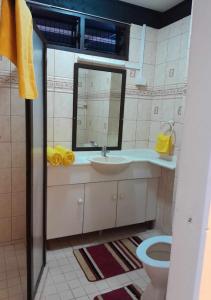 bagno con lavandino, specchio e servizi igienici di Villa 109 a Pacific Harbour