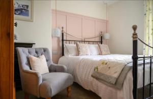 een slaapkamer met een bed en een stoel bij Coast Guest House in Whitby