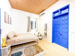 a bedroom with a bed and a blue door at La Casa Di Decembre - Nguyễn Như Đổ in Hanoi