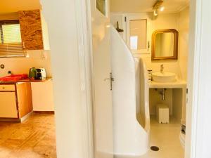 a white bathroom with a sink and a mirror at The Beachhouse Apartments in Vaia