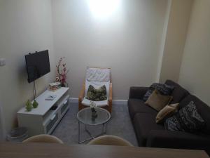 een woonkamer met een bank en een stoel bij 'The Potting Shed' in Knaresborough