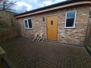 twee stoelen voor een bakstenen gebouw bij 'The Potting Shed' in Knaresborough