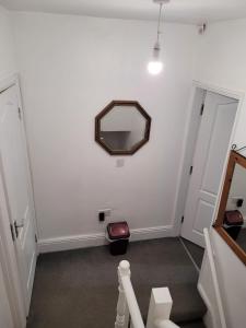 un couloir avec un miroir sur un mur blanc dans l'établissement En-suit on chilwell street, à Nottingham