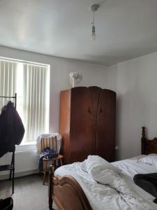 - une chambre avec un lit et une tête de lit en bois dans l'établissement En-suit on chilwell street, à Nottingham