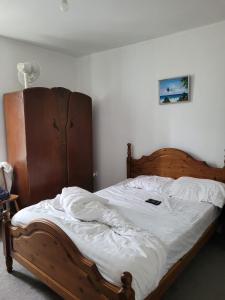 a bedroom with a wooden bed with white sheets at En-suit on chilwell street in Nottingham