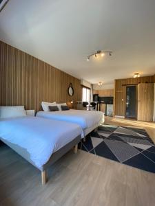 een slaapkamer met 2 bedden en een tafel bij Studios & chambres aux portes de Genève in Saint-Julien-en-Genevois