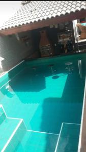 einen Pool mit blauem Wasser und Stühlen in der Unterkunft Casa mobiliada para periodo da tecnoshow 3 quartos sendo uma suíte sala copa cozinha área de lazer com piscina e bar molhado com churrasqueira 4 banheiros cozinha montada na área de lazer com 2 churrasqueiras elétrica e comum in Rio Verde