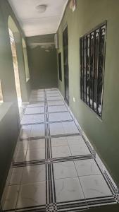 a hallway with a tile floor in a house at Malikia Apartment 1 in Brusubi