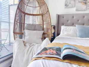 un dormitorio con un libro en una cama con una jaula para pájaros en INFIVILLA Deluxe Suites in Downtown Toronto with Amazing View en Toronto