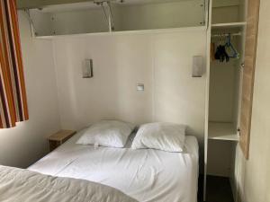 Soursac的住宿－Domaine du Lac，一间卧室配有带白色床单和枕头的床。