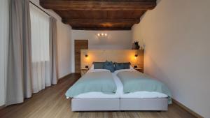 1 dormitorio con 1 cama grande con almohadas azules en Fruemess - Historic Refugium, en Parcines