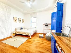 a kitchen with a bed in a room with wooden floors at La Casa Di Decembre - Nguyễn Như Đổ in Hanoi