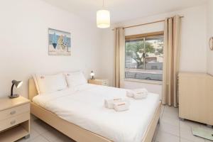 Un dormitorio con una cama blanca grande y una ventana en NEW - Portimao Casinha, en Praia da Rocha