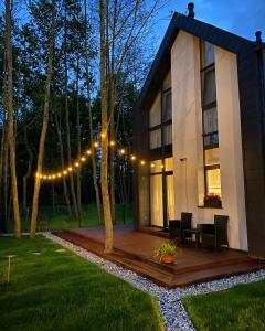 a house with a deck with lights on it at Sesiu Vilos @ Kunigiskes in Palanga