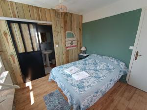 - une petite chambre avec un lit et une couverture bleue dans l'établissement La cocotte normande, à Coudeville-sur-Mer
