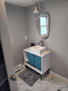 a bathroom with a white sink and a mirror at Middletown Modern Apartment w/ Private Deck - RIBryan Properties in Middletown +20 photos