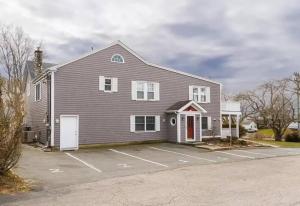 a large house with a parking lot in front of it at Middletown Modern Apartment w/ Private Deck - RIBryan Properties in Middletown