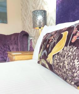 a bedroom with a bed with a pillow and a lamp at Invergarry Room Only Guest House For Adults in Windermere