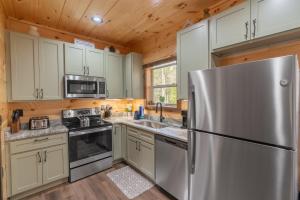 a kitchen with stainless steel appliances and wooden cabinets at Hawks Nest Mountain Cabin in Sevierville