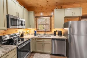 a kitchen with a stainless steel refrigerator and a sink at Hawks Nest Mountain Cabin in Sevierville