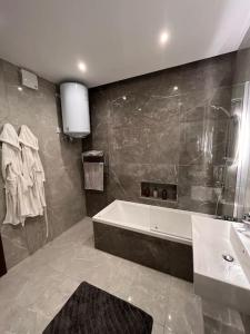 a bathroom with a bath tub and a sink at 3 Bedroom Seaside Luxury Accommodation - Sleeps 8 in St Paul's Bay +29 photos