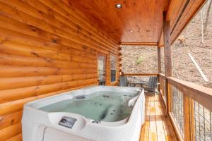 a jacuzzi tub on the deck of a tree house at Brand New Cabin in the Smokies in Sevierville