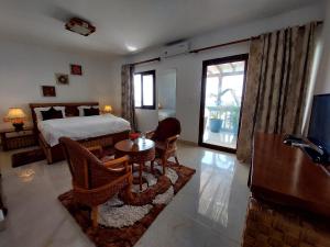 BenguelaにあるHotel Residencial Ramire-Tourのベッドルーム1室(ベッド1台、テーブル、椅子付)
