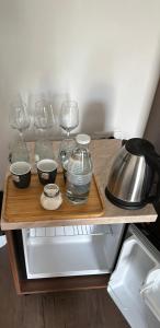 a shelf with wine glasses and bowls and a kettle at GuestHouse "Shtëpia ime" in Përmet