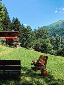 dwie ławki siedzące w trawie przed domem w obiekcie Chalet Viñales w mieście Les Houches