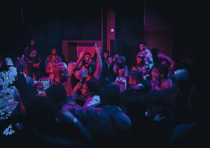 a crowd of people in a room with their hands in the air at JOST Auberge de Jeunesse Lille Centre in Lille